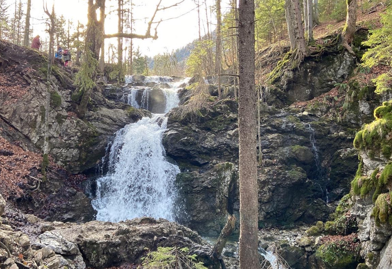 Wasserfall zwischen Felsen und Bäumen in der Natur.