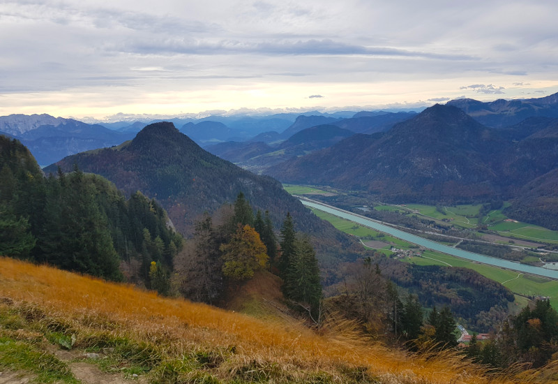Berglandschaft mit Fluss und bewaldeten Hügeln im Hintergrund.