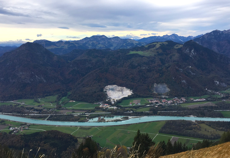 Berglandschaft mit Fluss, Wiesen und kleinen Ortschaften.