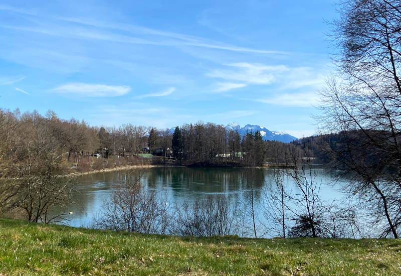 Idyllischer See mit Bergen und blauem Himmel.