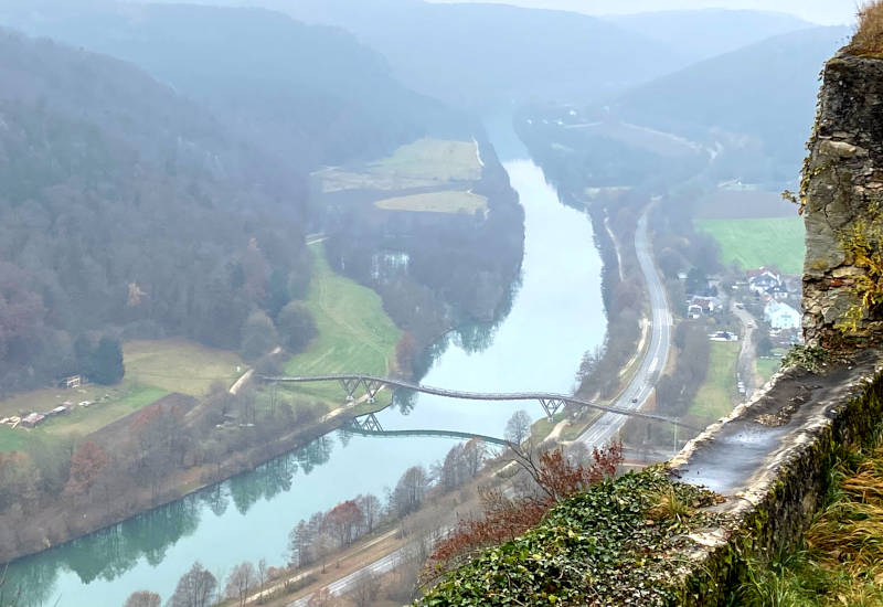 Blick auf einen Fluss, Brücke und umliegende Landschaft.