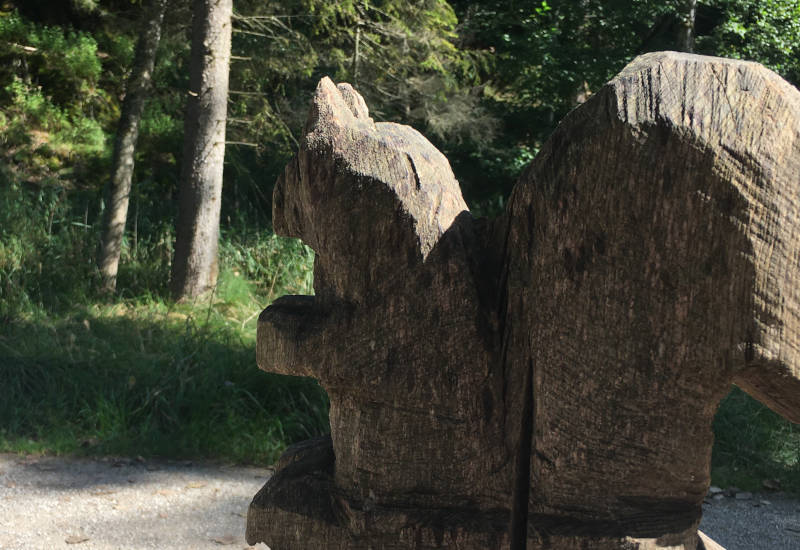 Holzskulptur eines Eichhörnchens im Wald.